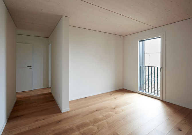 Rénovation énergétique Minergie d'un immeuble locatif des années 80 à Fribourg avec extension en bois: vue intérieure de l'extension en bois
