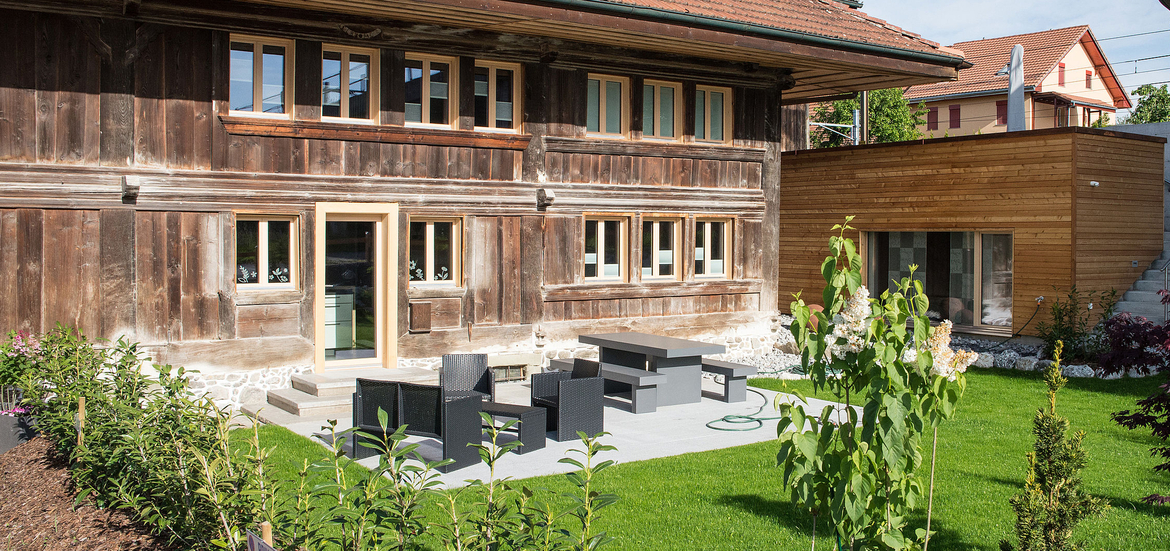 Transformation d'une ferme protégée à Fribourg: façades extérieurs et agrandissement bois